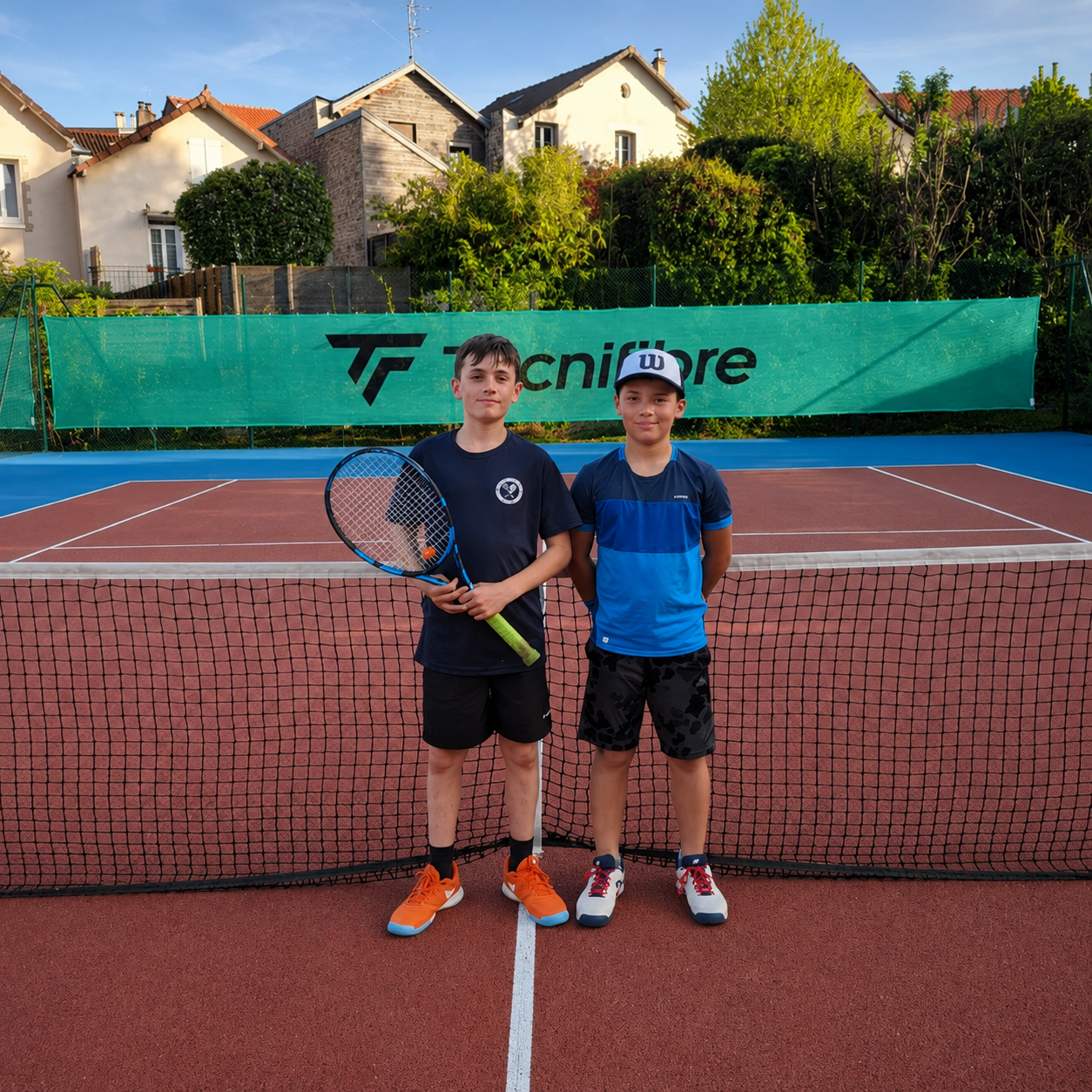 Deux jeunes joueurs sur un court de tennis du club